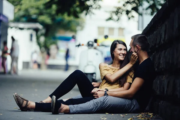 Jovem casal bonito sentado no chão — Fotografia de Stock