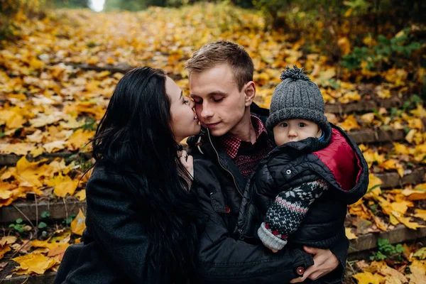 Молода сім'я і новонароджений син в осінньому парку — стокове фото