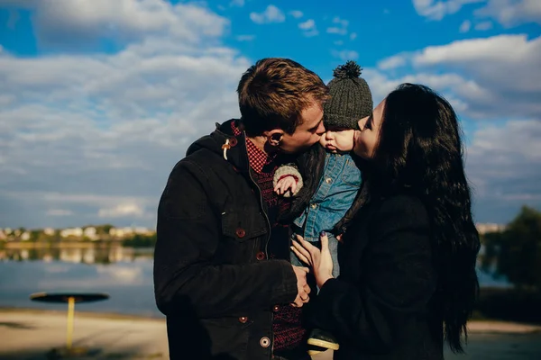 Giovane famiglia e figlio passeggiata lungo la riva del lago — Foto Stock