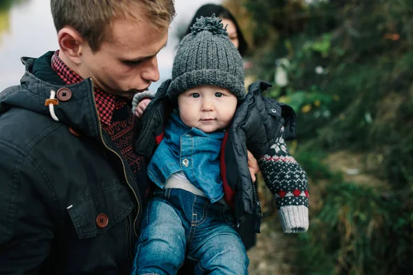 Jong gezin en zoon wandeling langs de oever van het meer — Stockfoto