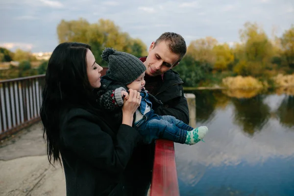 Giovane famiglia e figlio passeggiata lungo la riva del lago — Foto Stock