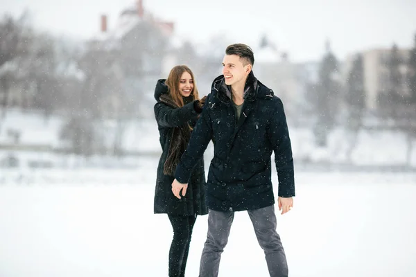 Paar poseren in een besneeuwde park — Stockfoto