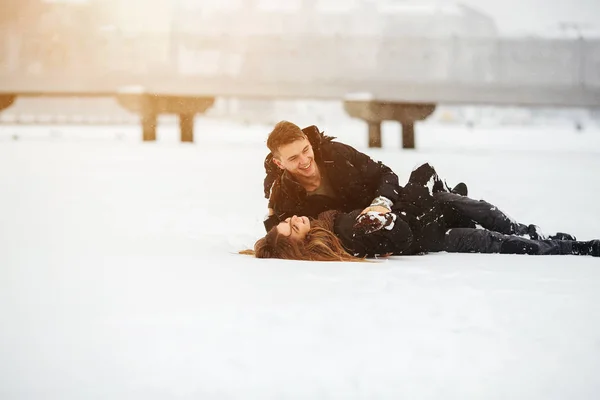 Meisje en jongen liggen op sneeuw — Stockfoto