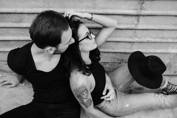 Man and woman posing on a background gray wall — Stock Photo, Image