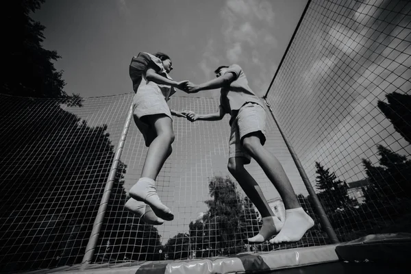 Para, skoki na trampolinie w parku — Zdjęcie stockowe