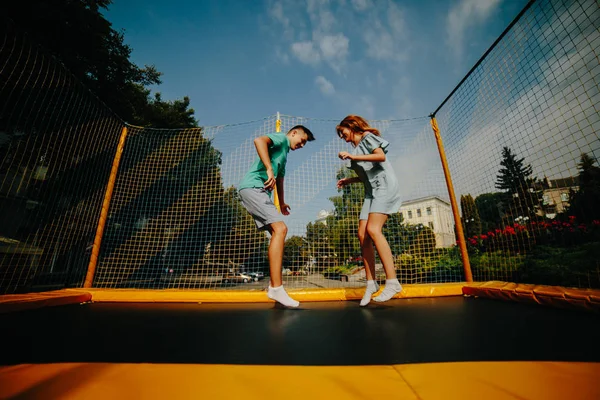 Casal pulando no trampolim no parque — Fotografia de Stock