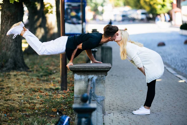 Uomo esegue un trucco acrobatico vicino a una ragazza — Foto Stock