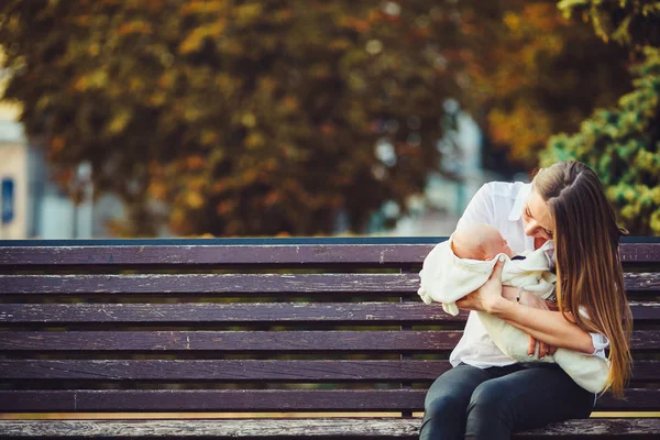 Mãe e duas filhas descansam em um banco — Fotografia de Stock