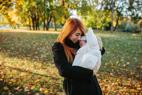 Matka i syn noworodka w jesienny park — Zdjęcie stockowe