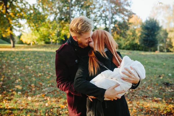 Familia joven e hijo recién nacido en el parque de otoño —  Fotos de Stock