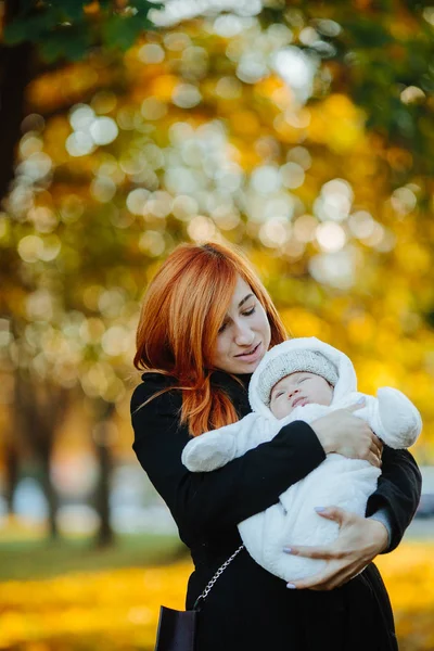 Madre e hijo recién nacido en el parque de otoño — Foto de Stock