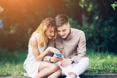 Ascot parkta oturan bir smartphone kullanarak