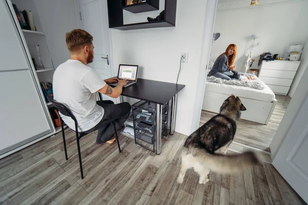 Papa arbeitet am Laptop, Mama und Baby auf dem Bett — Stockfoto