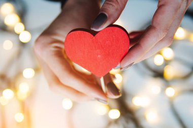 kırmızı bir kalp elinde tutan kız