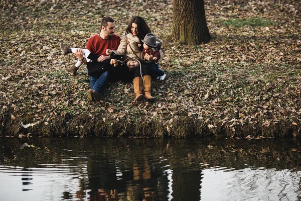 Family resting on the river bank — Stock Photo, Image