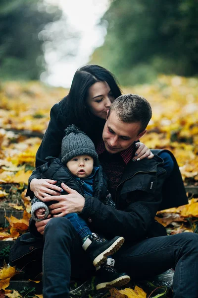 Jovem família e filho recém-nascido no parque de outono — Fotografia de Stock