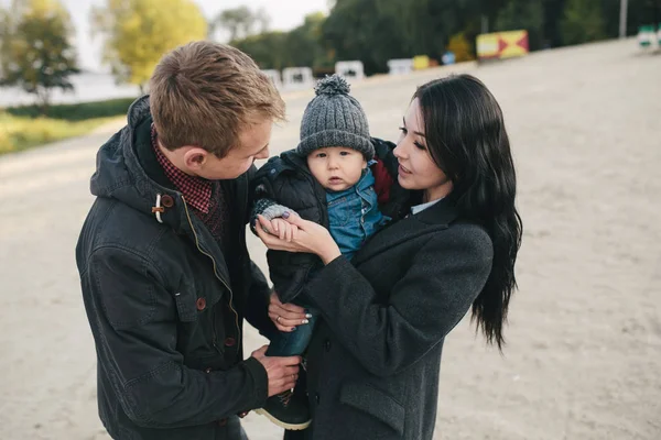 Jeune famille et fils marchent le long de la rive du lac — Photo