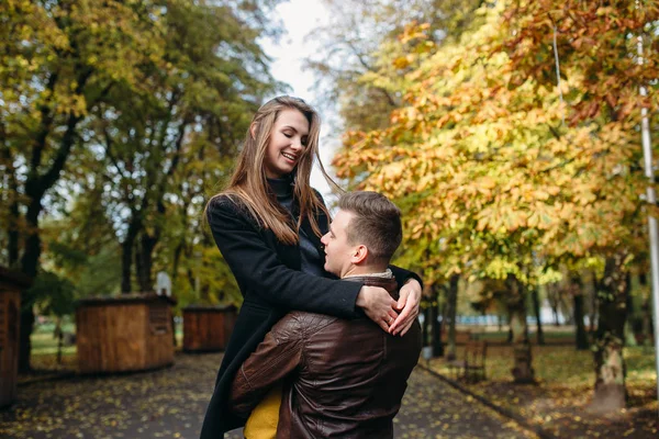 Attractive happy couple walking in autumn park — Stock Photo, Image