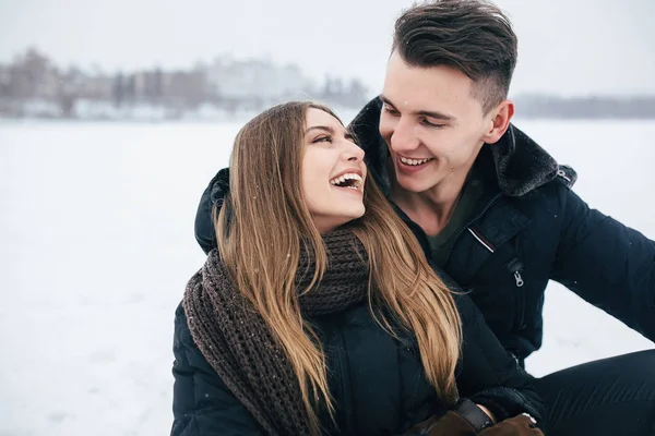 Paar zittend op de sneeuw — Stockfoto