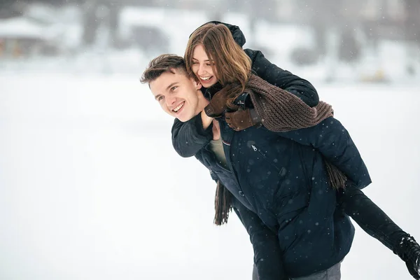 Man carries his girlfriend on the back — Stock Photo, Image