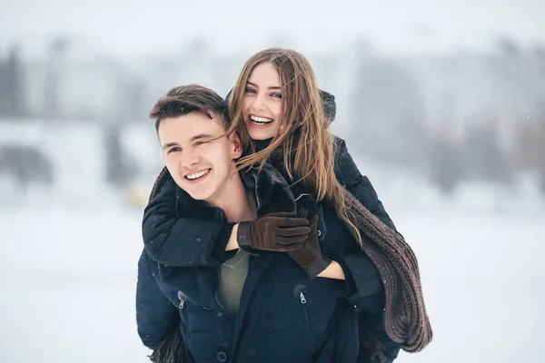 Man carries his girlfriend on the back — Stock Photo, Image