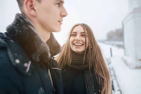 Paar poseren in een besneeuwde park — Stockfoto