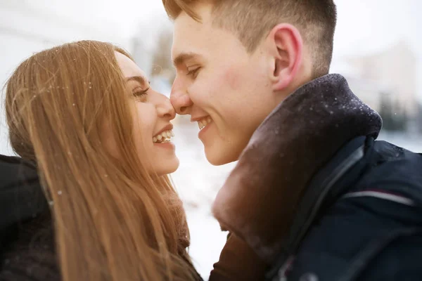 Par poserar i en snöig park — Stockfoto