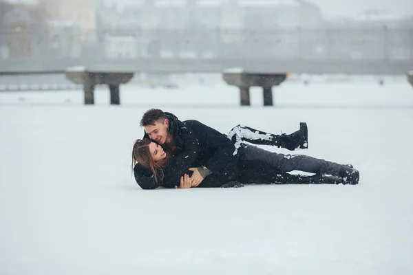 Meisje en jongen liggen op sneeuw — Stockfoto