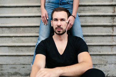 adam arka plan gri duvara oturur