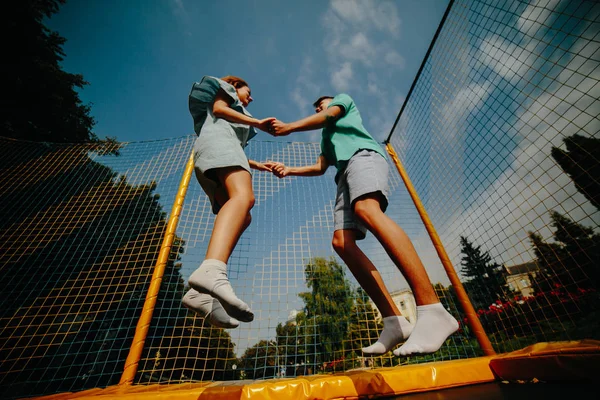 Pár jumping a trambulin-a parkban — Stock Fotó
