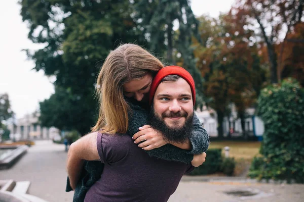 Мужчина носит свою девушку на спине — стоковое фото