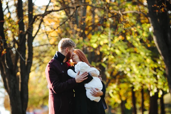 Familia joven e hijo recién nacido en el parque de otoño —  Fotos de Stock