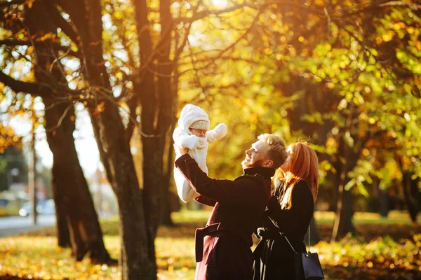 Νεαρή οικογένεια και ο νεογέννητος γιός στο πάρκο φθινόπωρο — Φωτογραφία Αρχείου