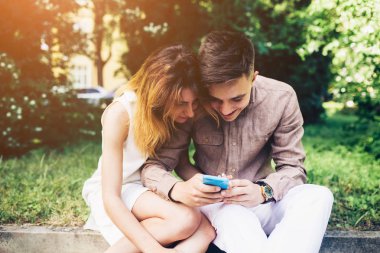 Ascot parkta oturan bir smartphone kullanarak