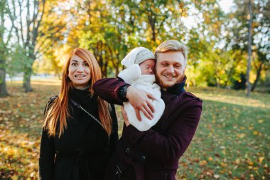 Genç aile ve sonbahar Park yeni doğan oğlu