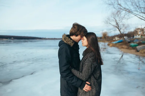 Jovem casal bonito no gelo de um lago congelado — Fotografia de Stock