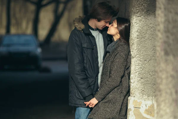 Jovem casal de pé juntos na frente da parede — Fotografia de Stock