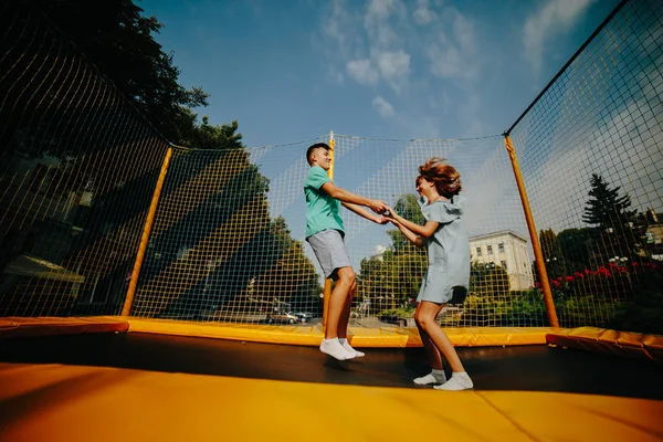 Coppia che salta sul trampolino nel parco — Foto Stock