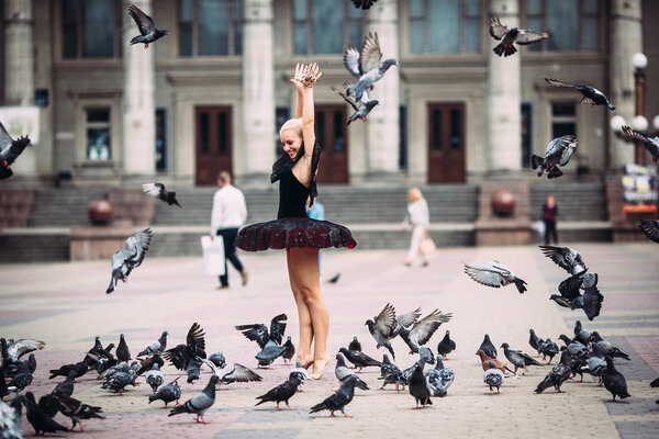 Ballerina posing among birds