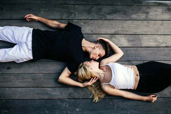 Couple lying together on the hardwood floor — Stock Photo, Image