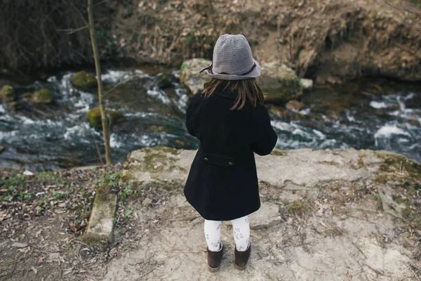 Niña en un abrigo negro y sombrero — Foto de Stock