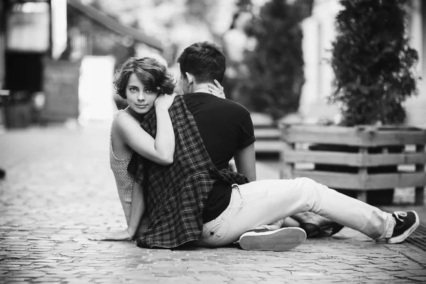 Man och kvinna som sitter på marken — Stockfoto