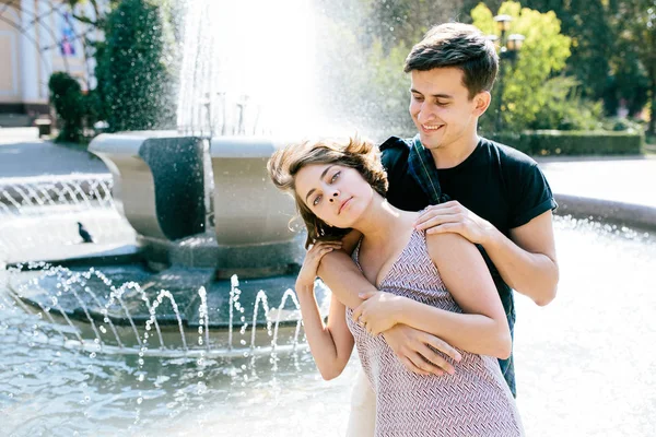 一对年轻貌美的情侣在喷泉前 — 图库照片