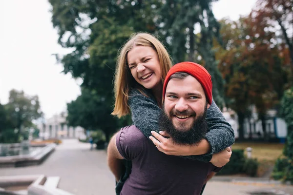 Mann trägt Freundin auf dem Rücken — Stockfoto