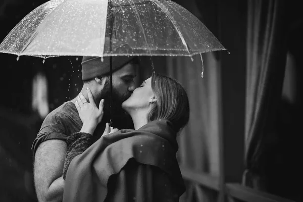 Cara e a menina beijando sob um guarda-chuva — Fotografia de Stock