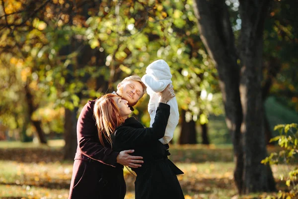 Familia joven e hijo recién nacido en el parque de otoño — Foto de Stock