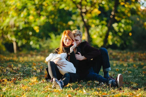 Young family and newborn son in autumn park — Stock Photo, Image