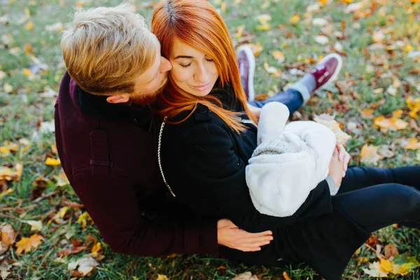 Junge Familie mit neugeborenem Sohn im Herbstpark — Stockfoto