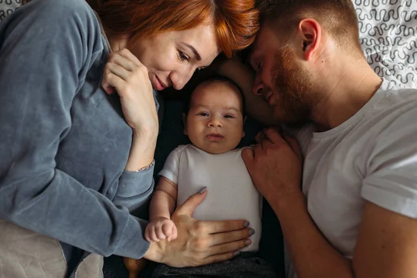 Padres jóvenes que prestan atención a su bebé . — Foto de Stock