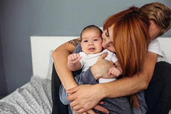 Keluarga bahagia dengan bayi yang baru lahir di tempat tidur — Stok Foto